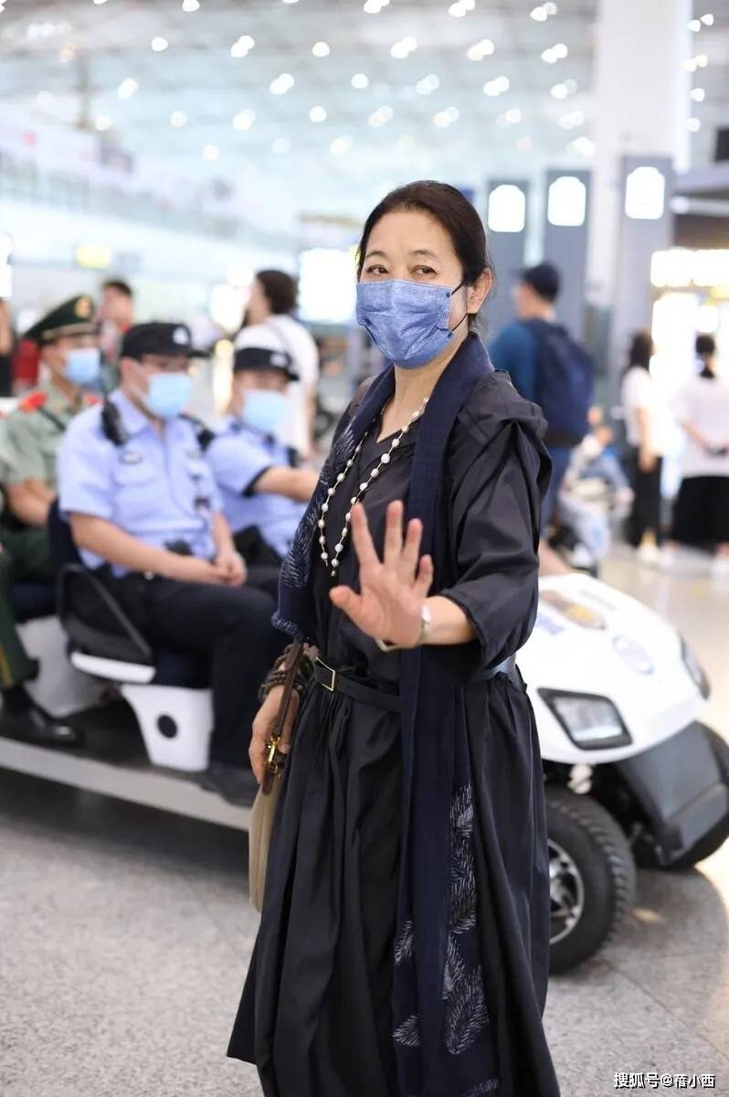 66岁倪萍走机场太时髦！穿连衣裙+运动鞋+丝巾，美得像换了个人